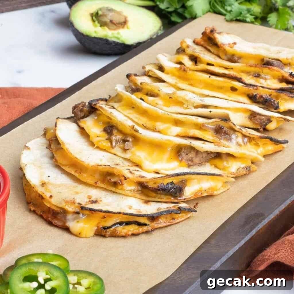 Carne asada mulitas on a cutting board with jalapenos and avocado.