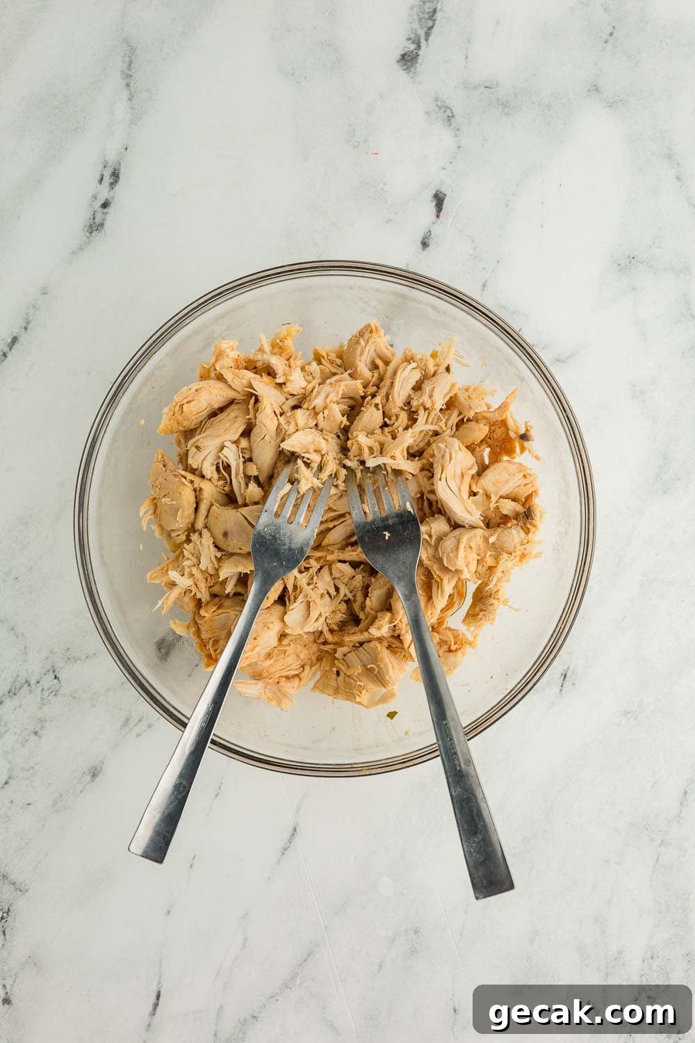 Slow Cooker Buffalo Chicken Dip: Creamy Cheesy Party Recipe 5 Shredded chicken with two forks in clear bowl