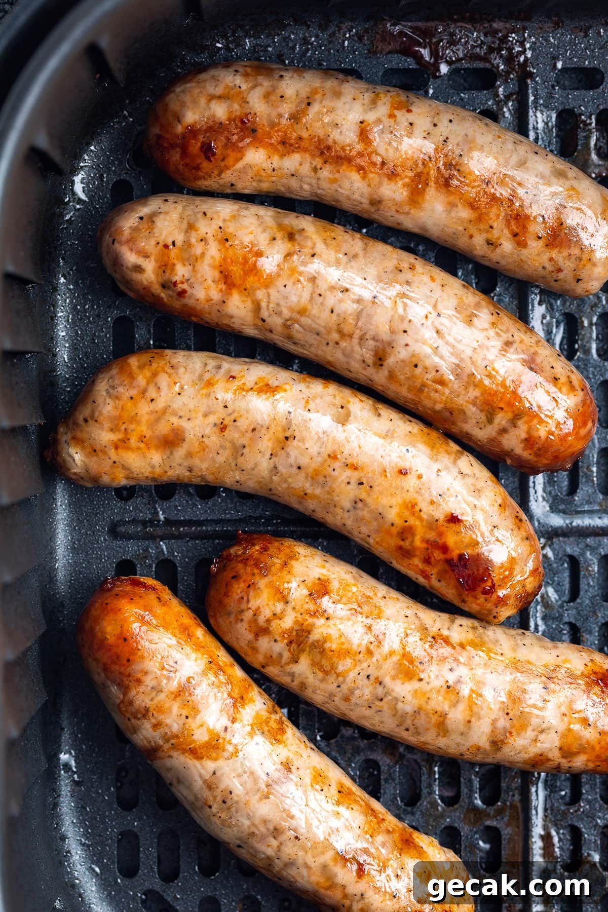 Crispy Air Fryer Italian Sausage Recipe for Quick Dinner 2 Overhead view of 5 Italian sausages in an air fryer basket.
