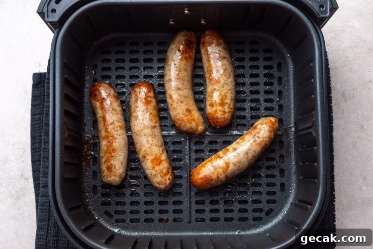 Crispy Air Fryer Italian Sausage Recipe for Quick Dinner 7 5 cooked Italian sausages in an air fryer basket.