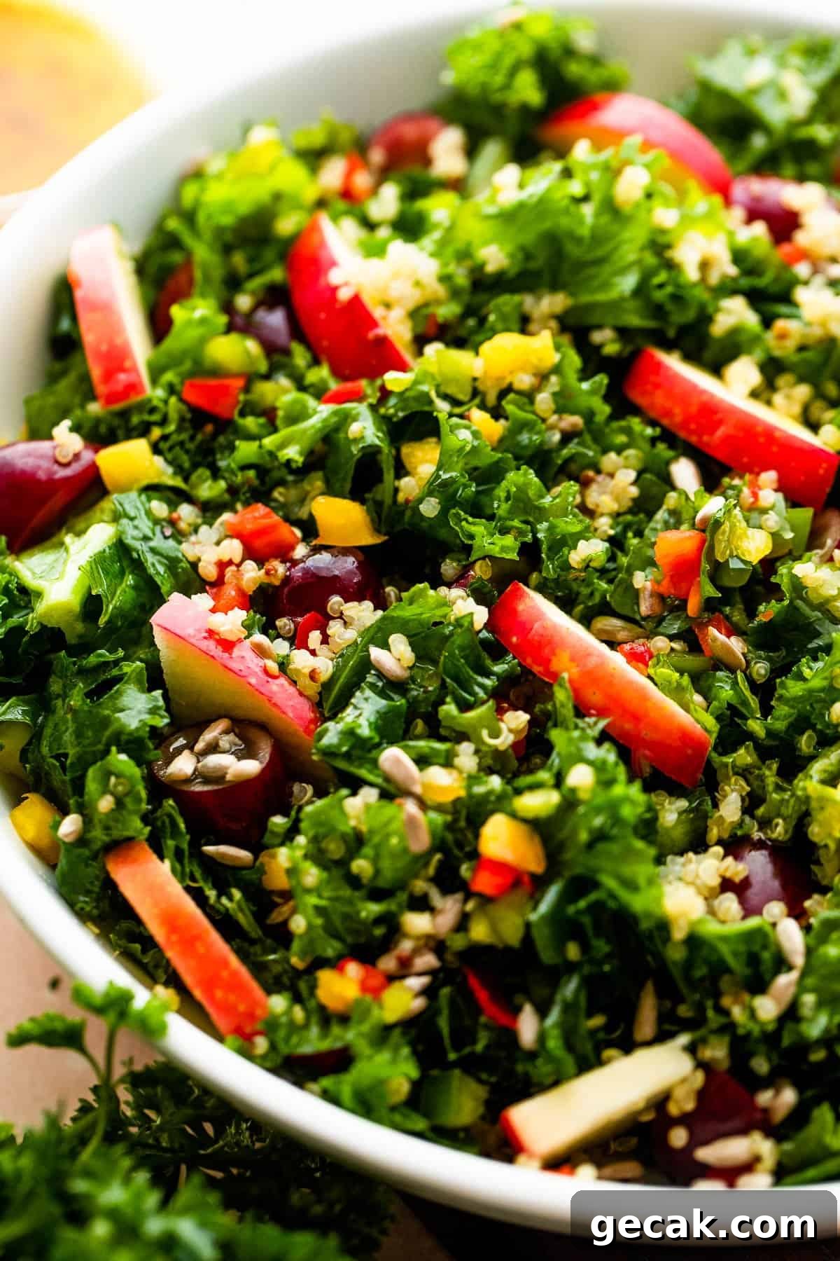 kale green salad studded with sliced red apples.