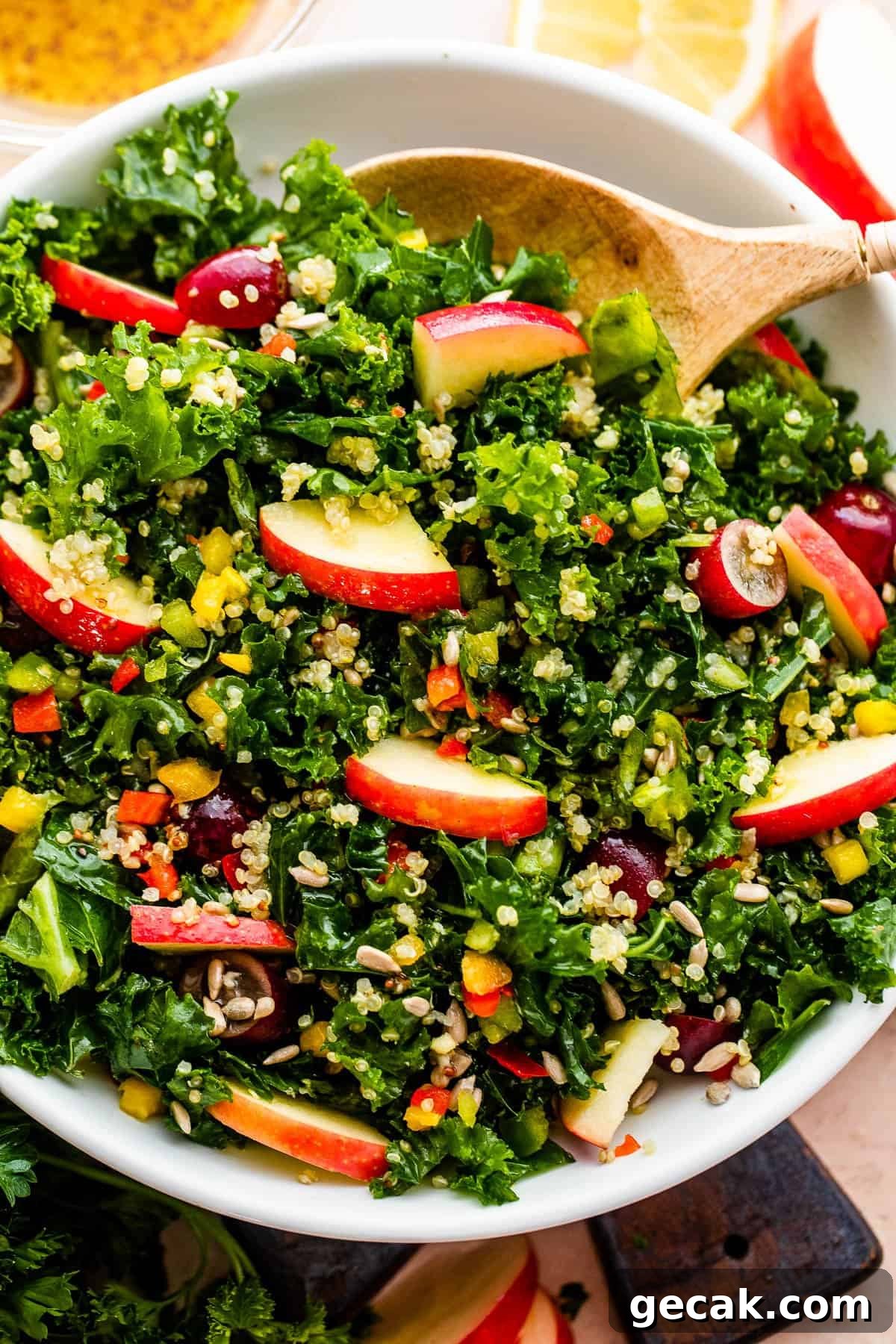 close up overhead shot of Crunchy Kale Quinoa Salad studded with apple slices, halved grapes, sunflower seeds, and bell peppers.