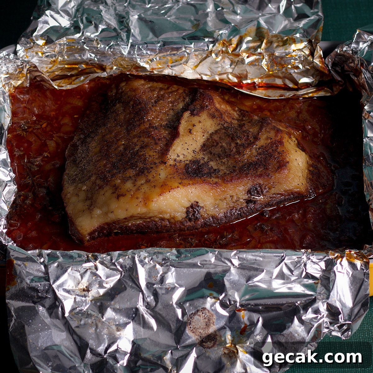 A cooked, tender brisket that's just been removed from the oven.
