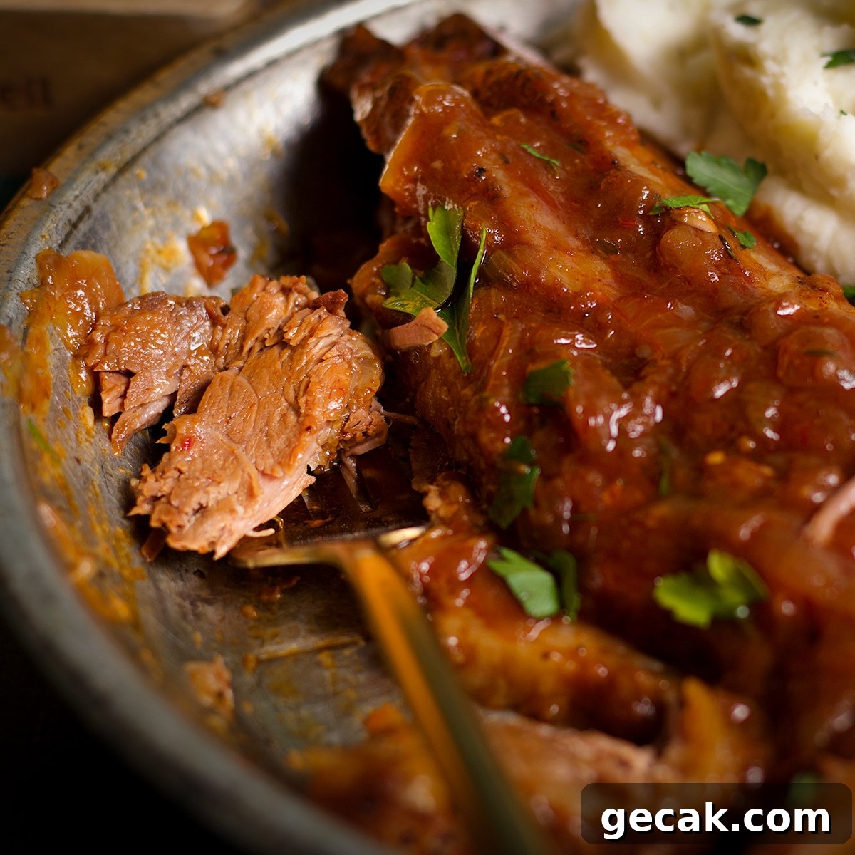 Someone using a fork to cut a bite of brisket from a slice.