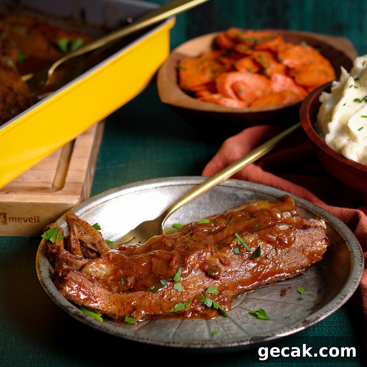 Several slices of braised beef brisket on a plate with a bowl of brown butter carrots and a bowl of buttermilk whipped potatoes on the table next to it.