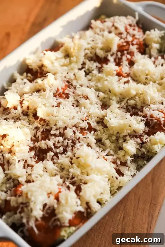 Vodka Ricotta Stuffed Pasta Bake with Creamy Tomato Sauce 9 A baking dish filled with stuffed shells, topped with shredded cheese and vodka sauce, ready to be baked in the oven.