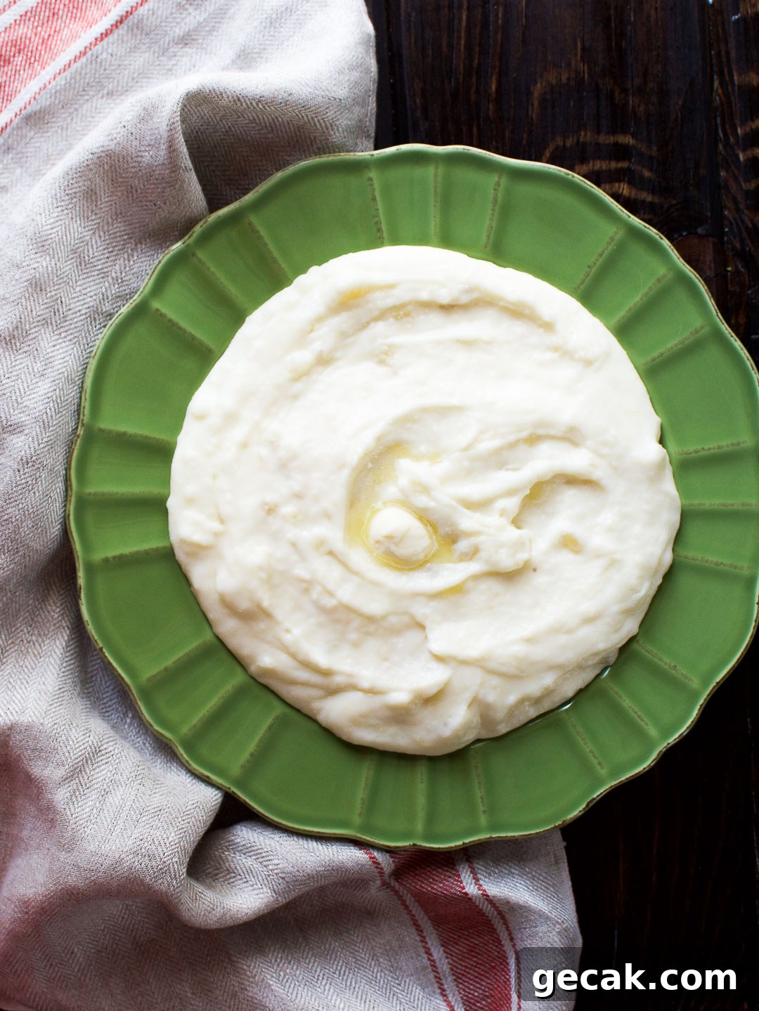 Mashed yuca in a green bowl over a kitchen towel