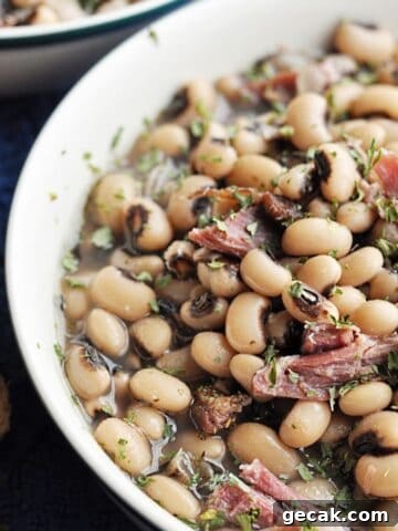 Cooked black eyed peas with ham served in bowl.