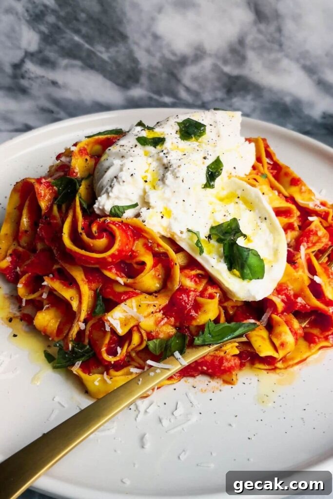 Turkish-Style Poached Eggs with Tomato and Yogurt Sauce 16 Spicy nduja pasta on a white plate with a ball of burrata on top.