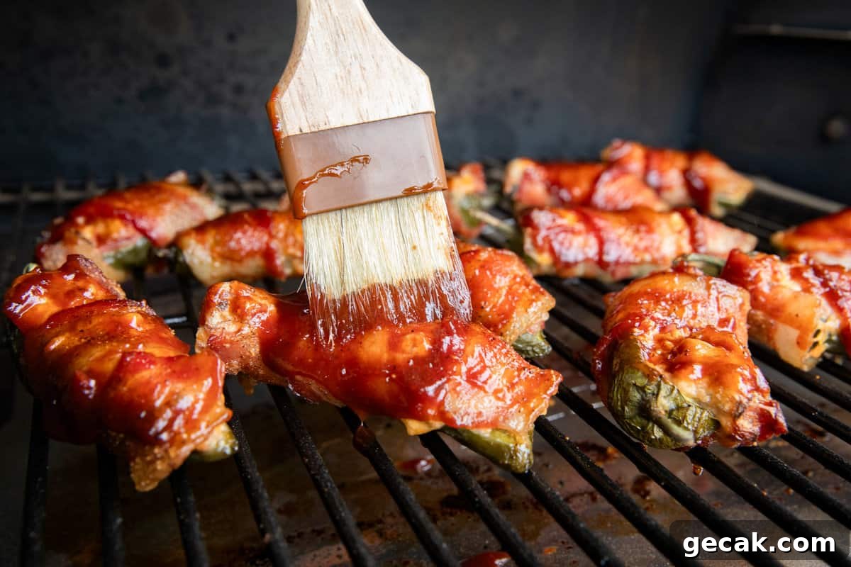 Brushing Texas Twinkies with BBQ sauce on grill
