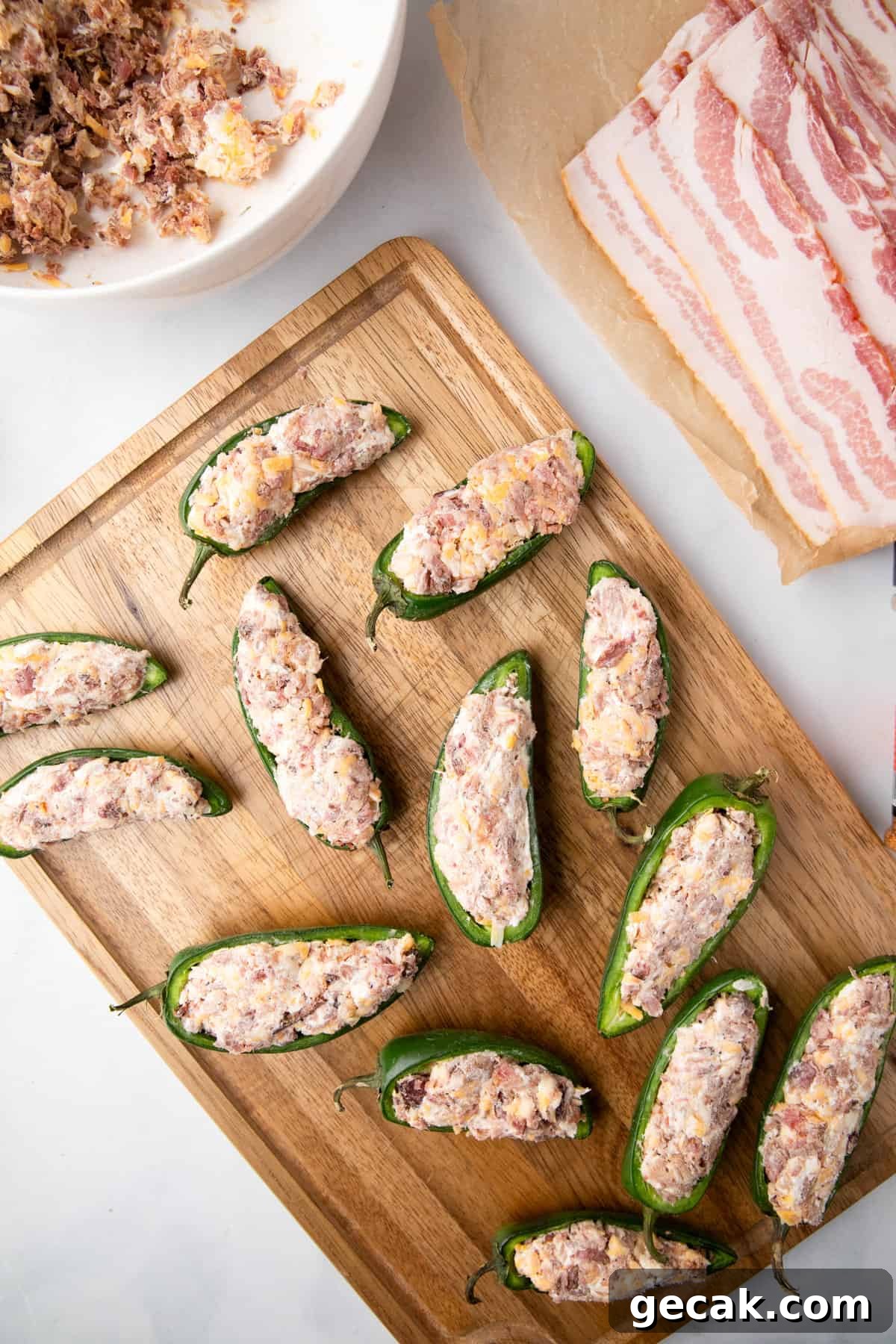 Sliced jalepenos filled with mixed stuffing arranged on cutting board