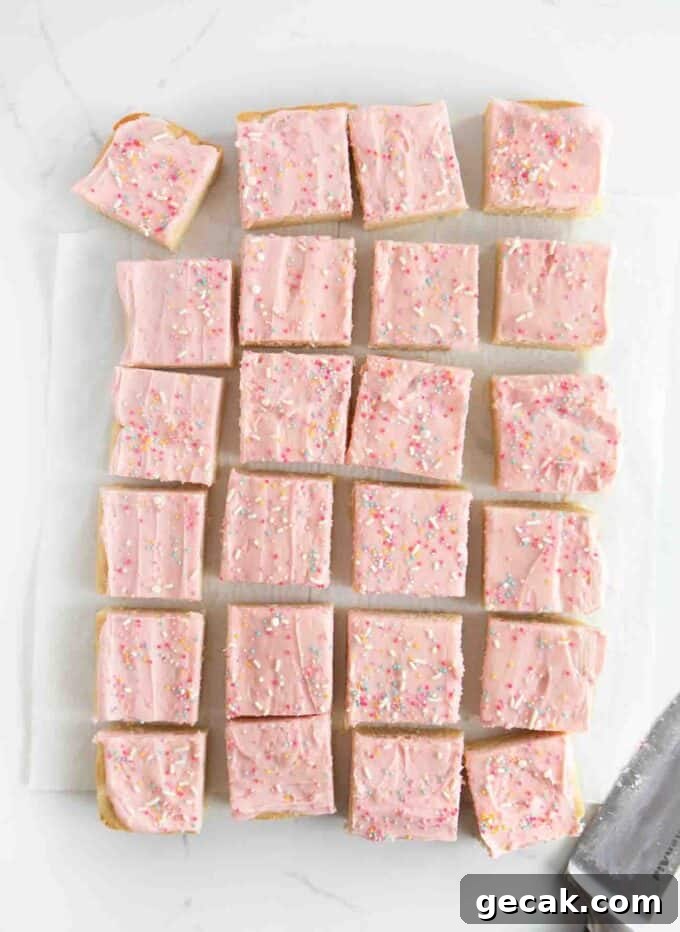 pan of cut sugar cookie bars with pink frosting and sprinkles