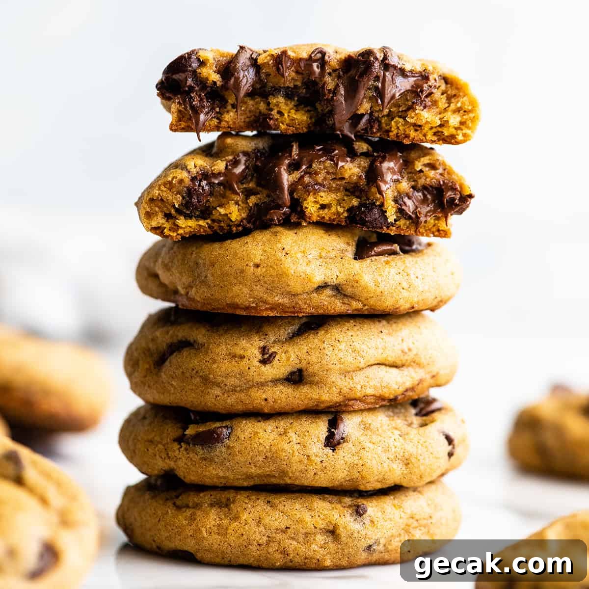 front view of a stack of 5 Pumpkin Chocolate Chip Cookies, the top one cut in half 