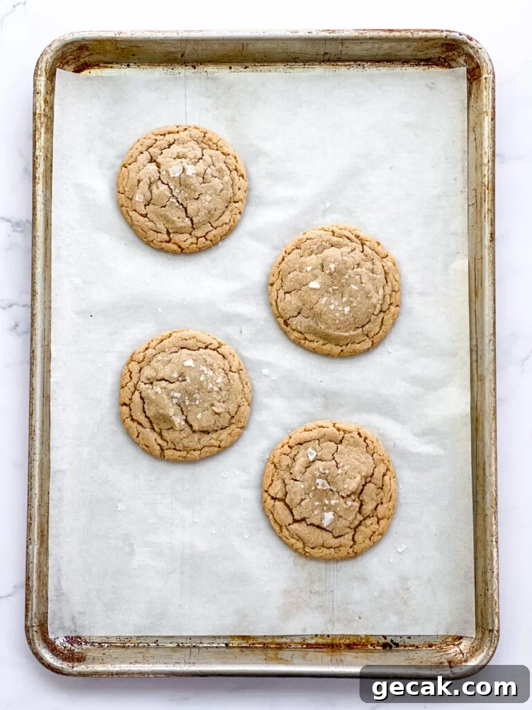 4 cookies freshly baked on cookie sheet