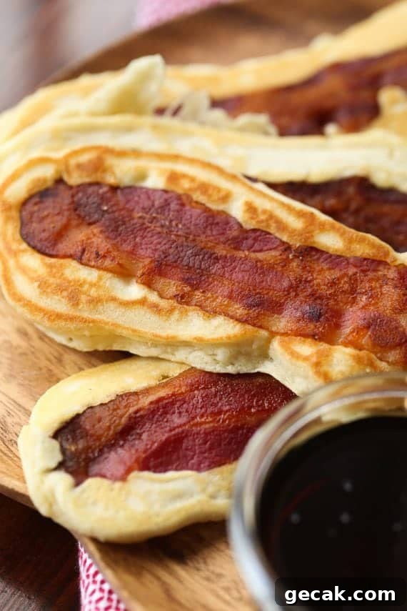Pancake Bacon Dippers! A soft pancake surrounds a crispy piece of bacon that you can dip right in maple syrup!