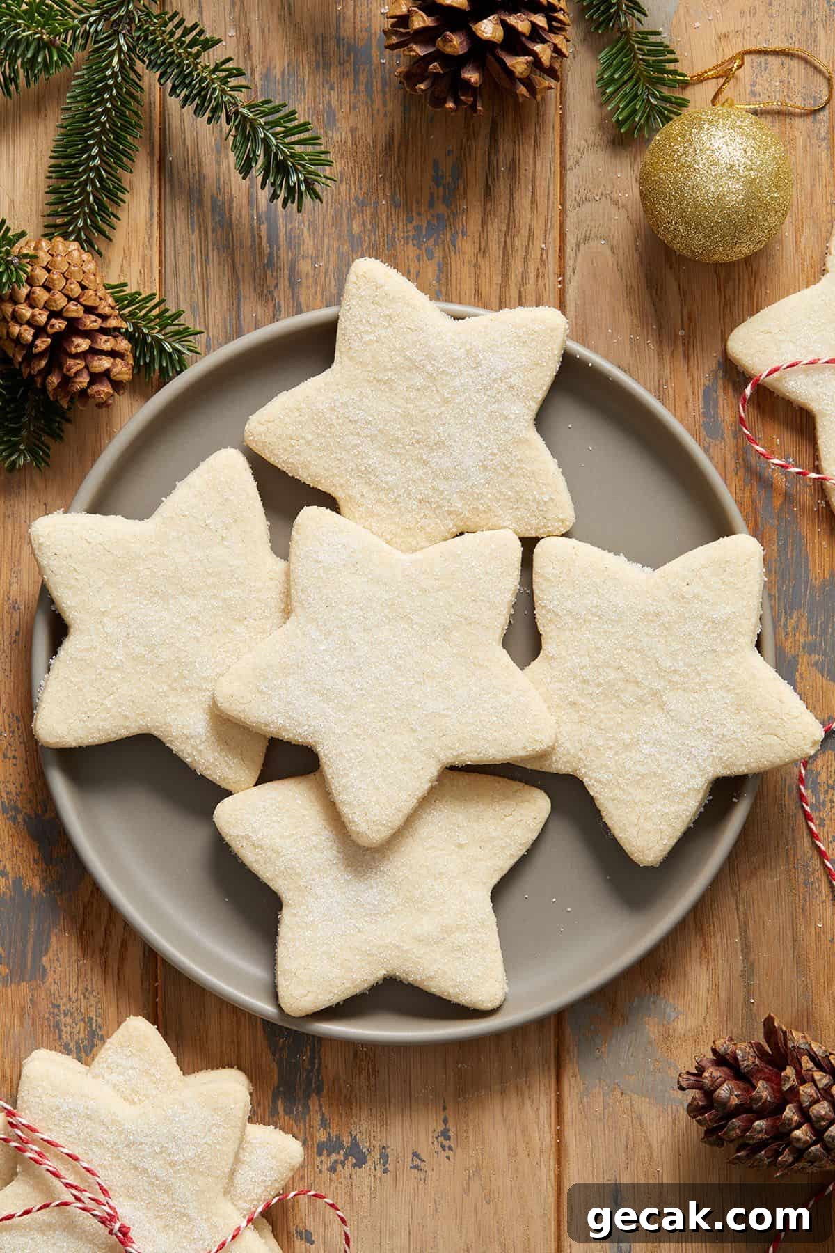 Round grey plate with five shortbread cookies, and some decorations around the edge of the photo.