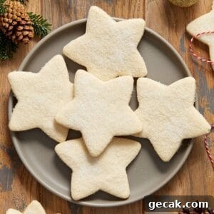 Round grey plate with five shortbread cookies, and some decorations around the edge of the photo.