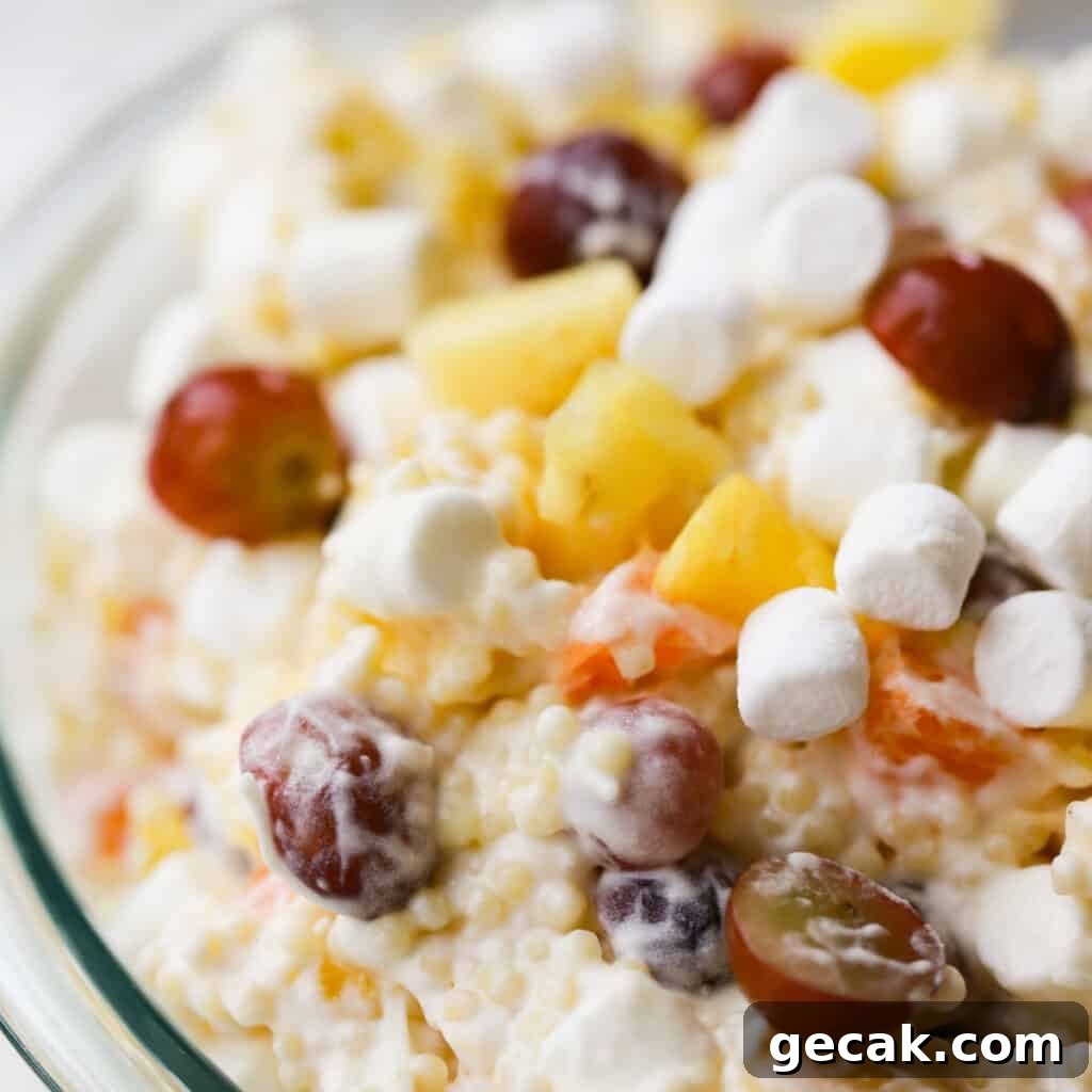 Classic Frog Eye Salad Recipe — Creamy Ambrosia-Style Dessert 4 A glass bowl full of this recipe for easy frog eye salad, full of grapes, mini marshmallows, and more.
