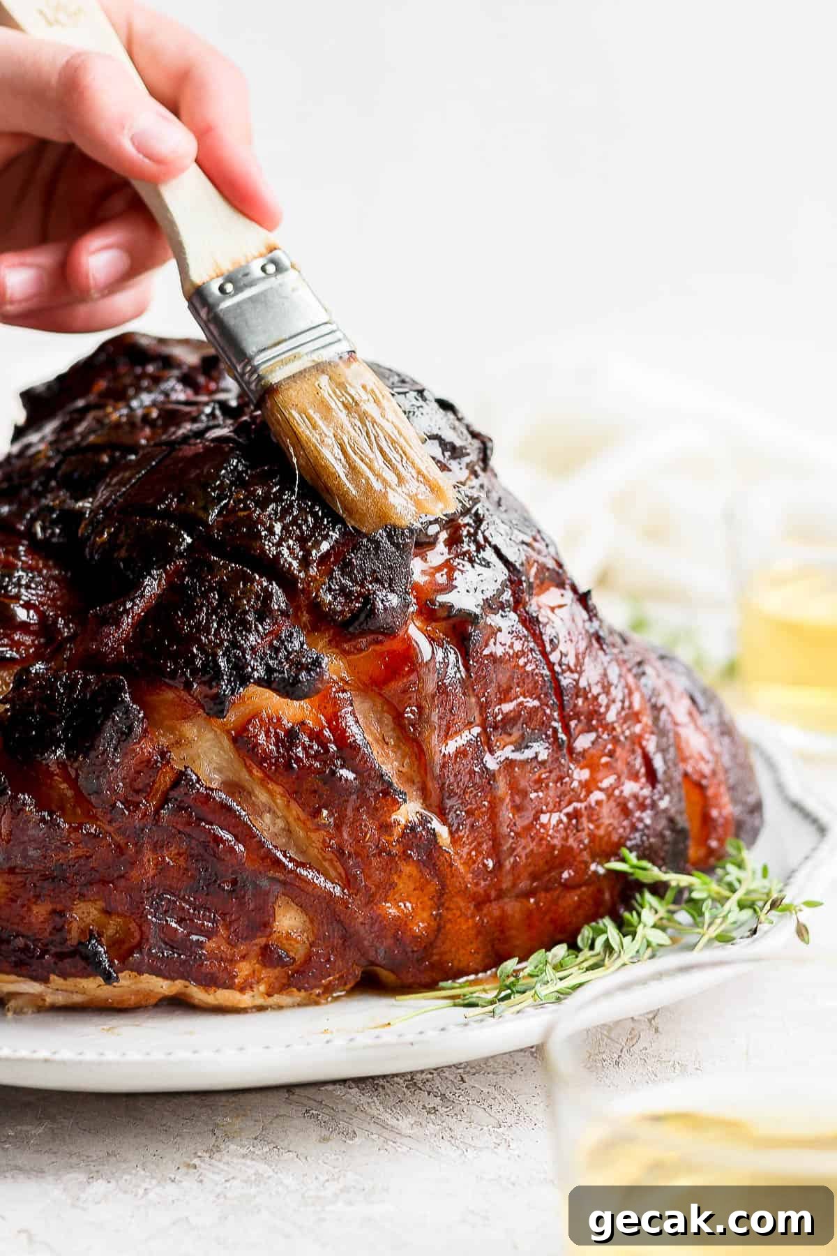 A brush basting the glaze on the ham.