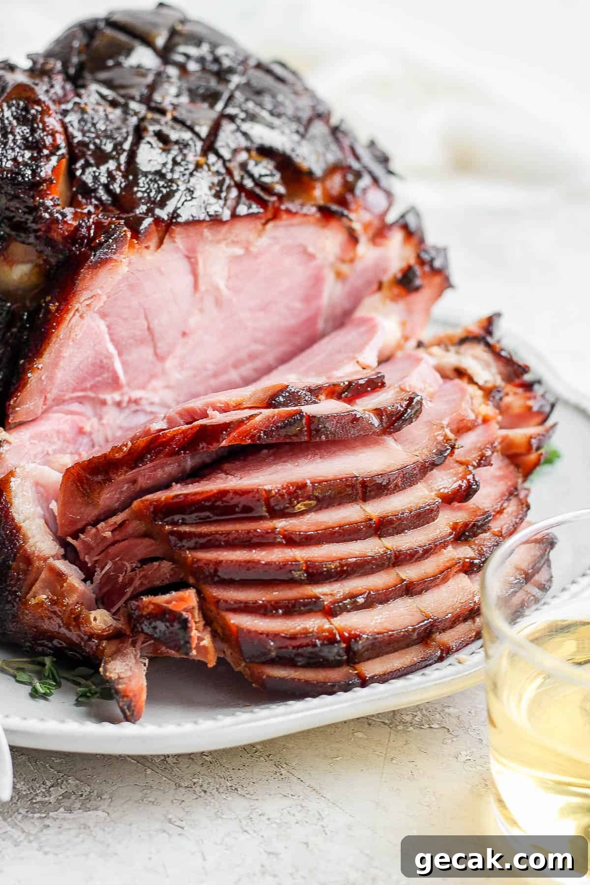 A honey bourbon glazed ham sliced on a plate.