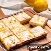 Nine keto lemon bars on a cutting board with a lemon in the background.
