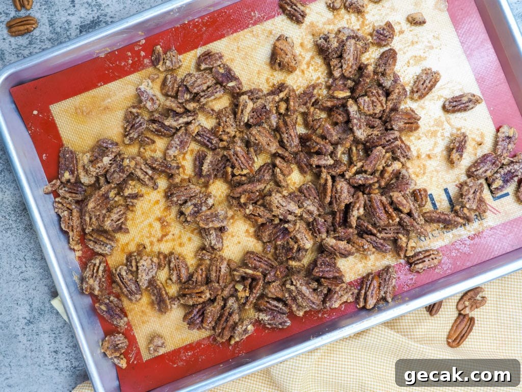 Bourbon Candied Pecans with Sweet & Spicy Glaze 10 a baking sheet with cooked candied pecans on it.