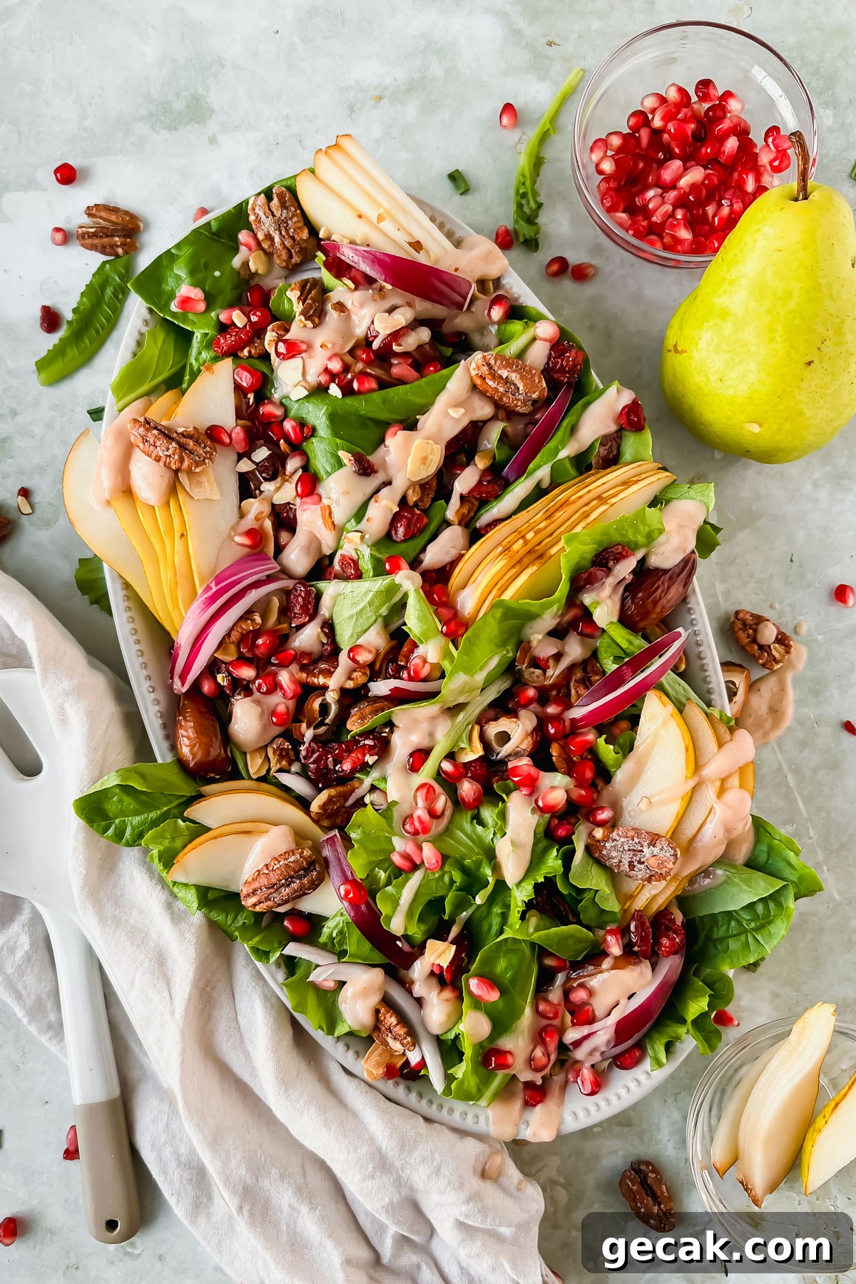 pear and pecan salad on white serving plate with homemade pear vinaigrette drizzled on top.