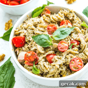 A bowl of tuna pasta pesto topped with fresh basil.