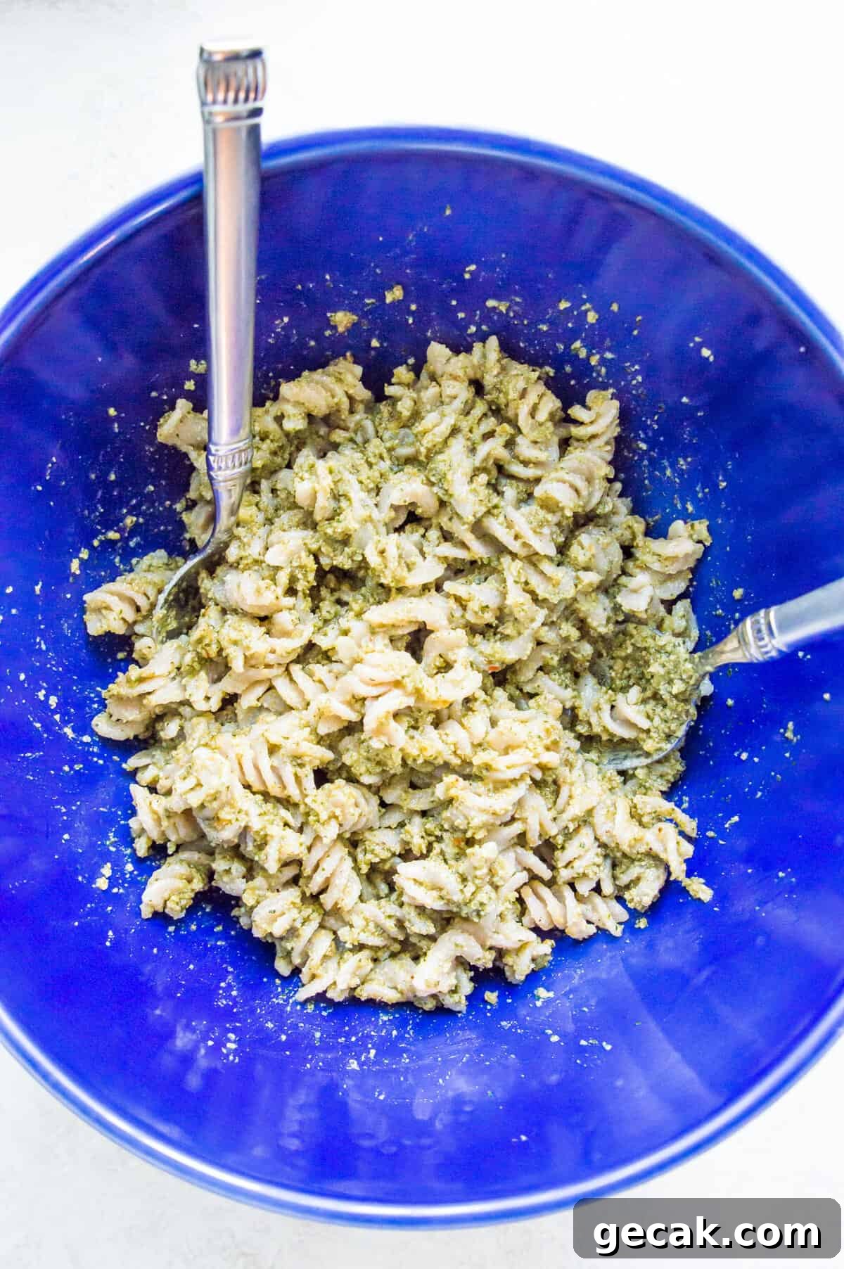 A bowl of pasta noodles covered in pesto.