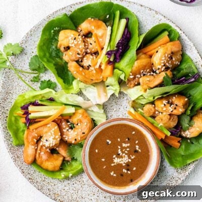 A plate showing lettuce wraps filled with spicy shrimp and crispy vegetables.