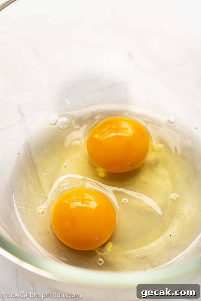 Savory Cauliflower Pancakes with Herbs and Parmesan 6 two eggs in a mixing bowl