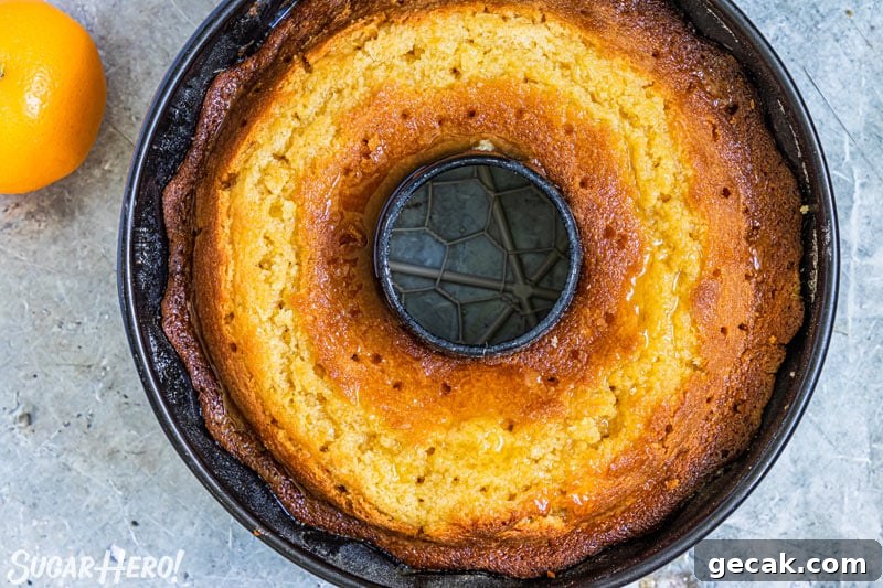 Baked bundt cake in a pan, with holes poked in top for syrup to seep in.