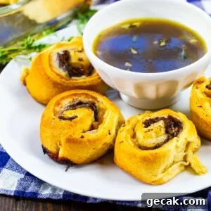 French Dip Pinwheels on a plate with a bowl of Au Jus.