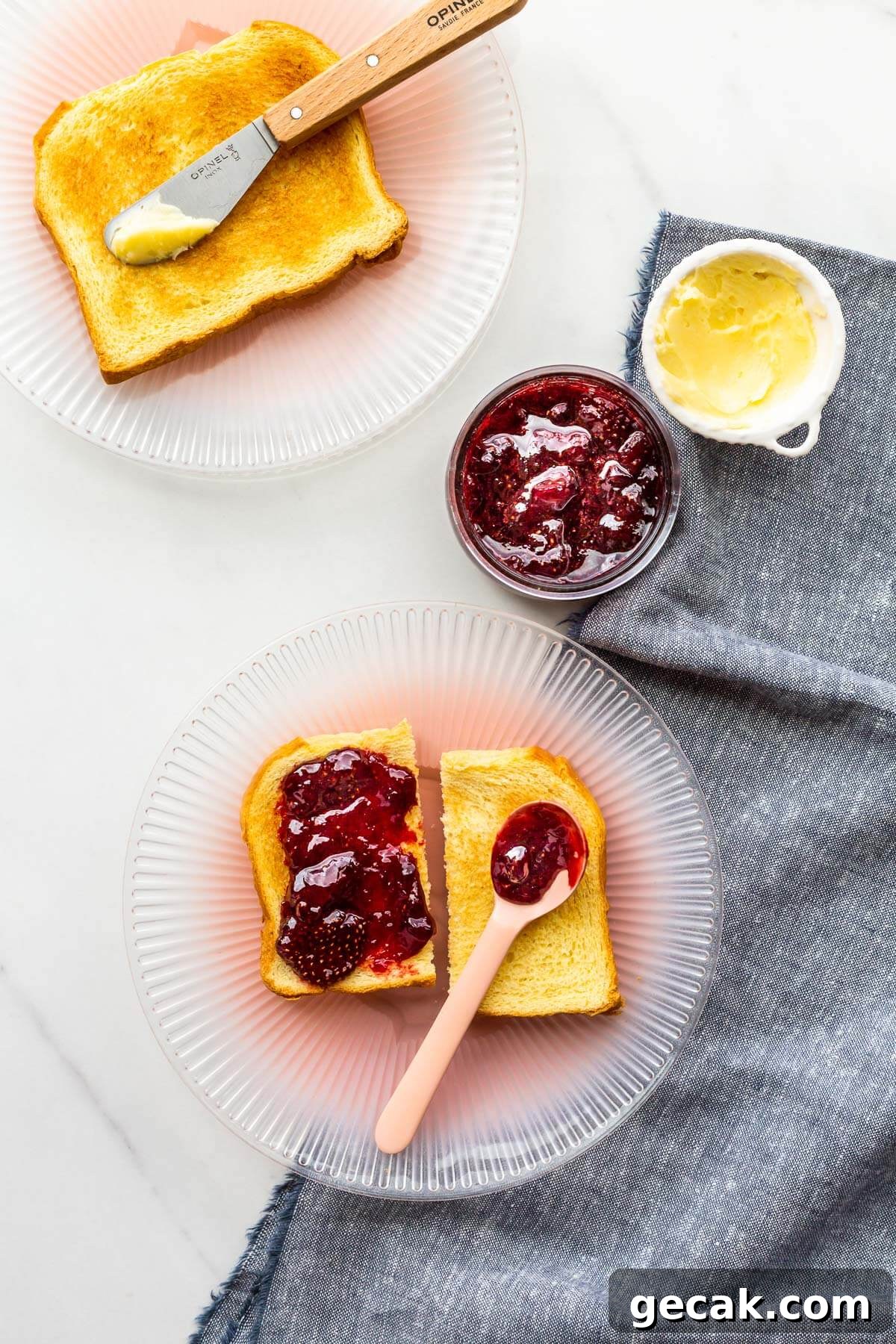 Smearing strawberry jam on toast.