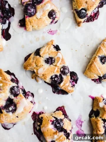 Scones with icing on parchment paper.