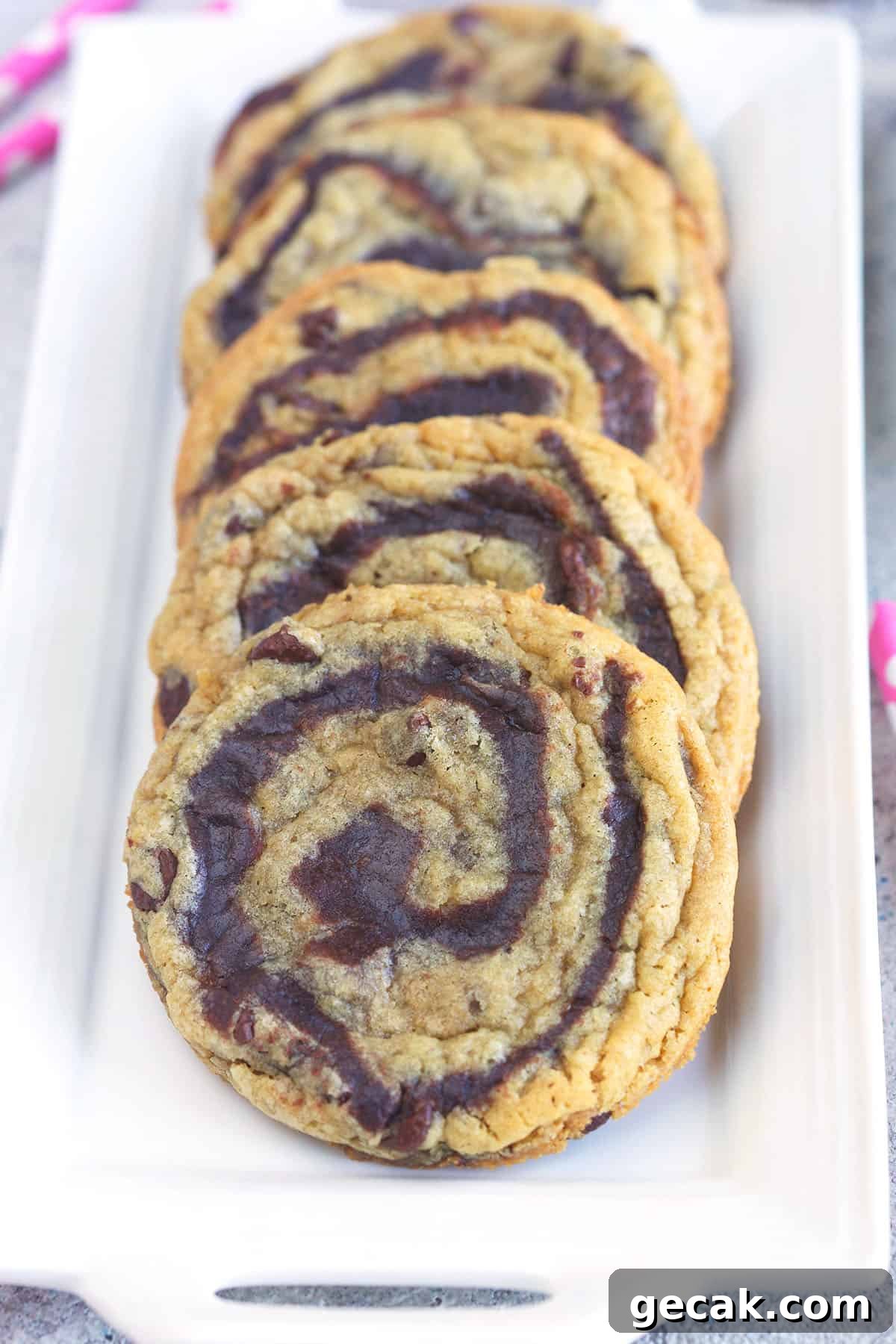 Several cookies are lined up on a white plate.
