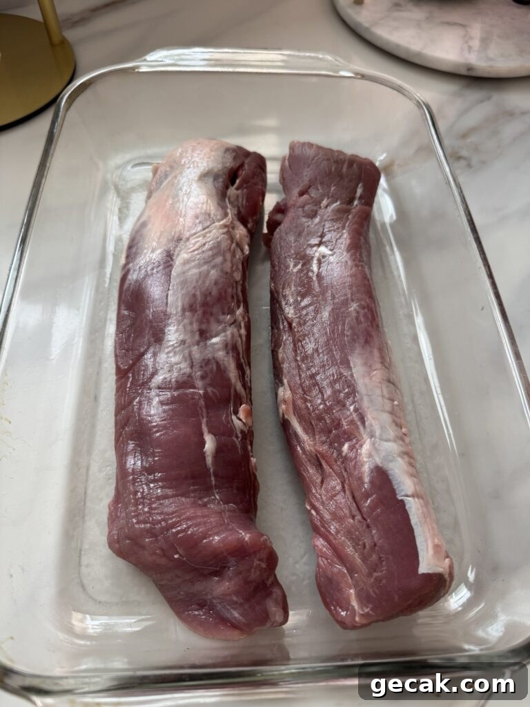 Two pork tenderloins in a glass baking dish