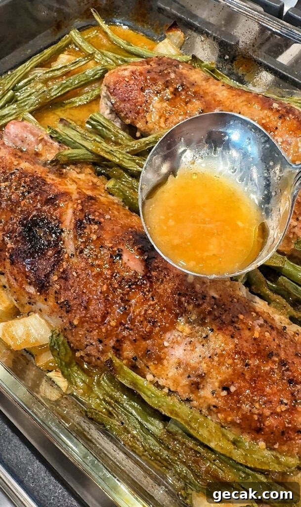 The sauce being ladled over the pork and green beans
