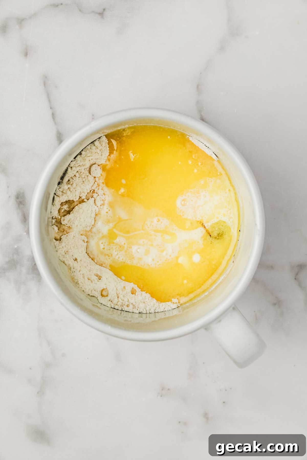 Mug cake avec des ingrédients et du beurre fondu 