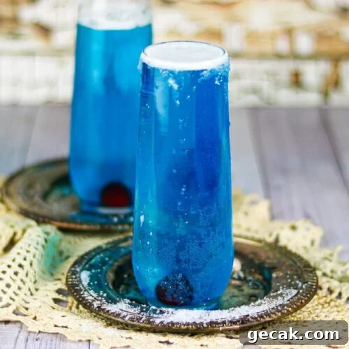 Two dark blue cocktails in champagne flutes.