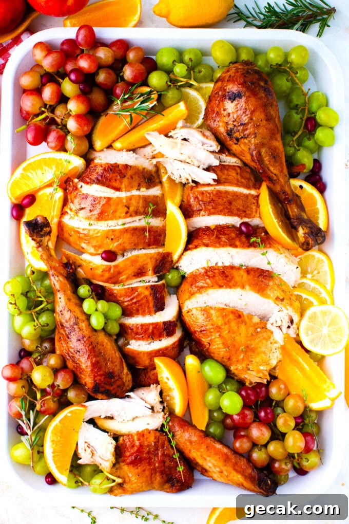 Carved oven roasted turkey on a platter with lemon and grapes.
