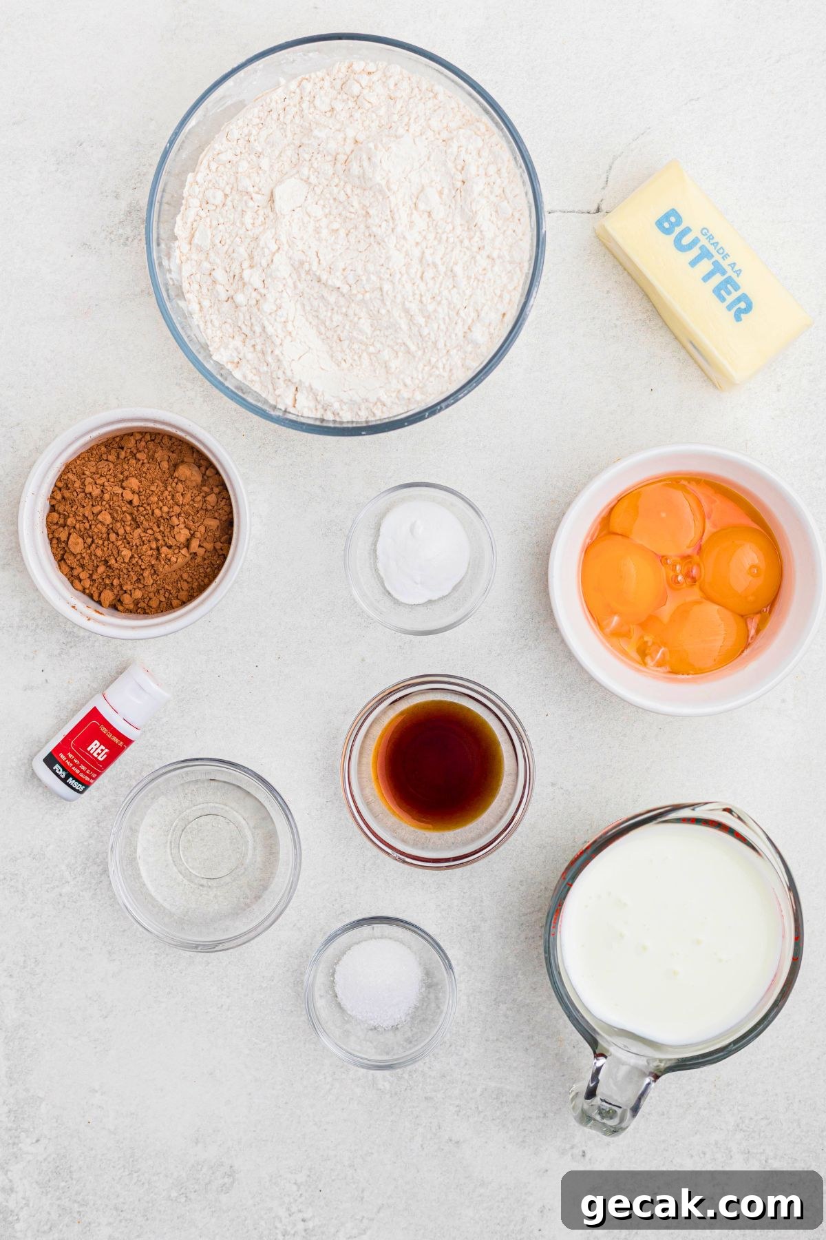 Ingredients needed to make red velvet cupcakes measure in small glass bowls.