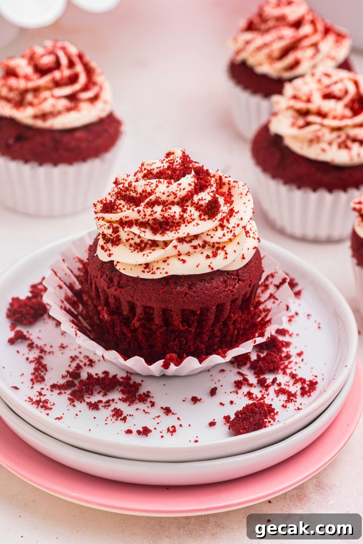 Bright red cupcake on a small white plate.