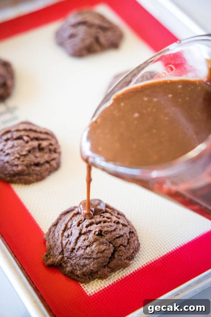 pouring chocolate frosting over cookies