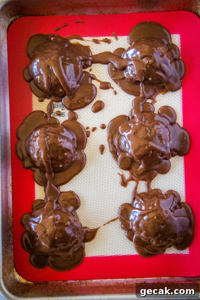 looking down on a tray of cookies with frosting poured all over them.