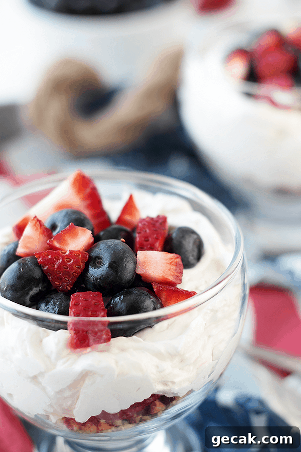 No-Bake Berry Cheesecake Parfait Recipe with Layered Berries 2 a glass bowl full of a layered berry cheesecake parfait