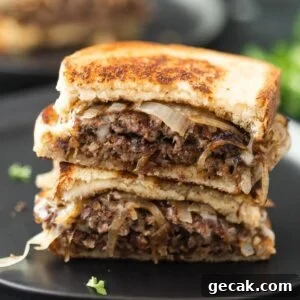 Patty Melt cut in half on a black plate.