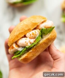 close up over head shot of hand holding prawn cocktail sandwich