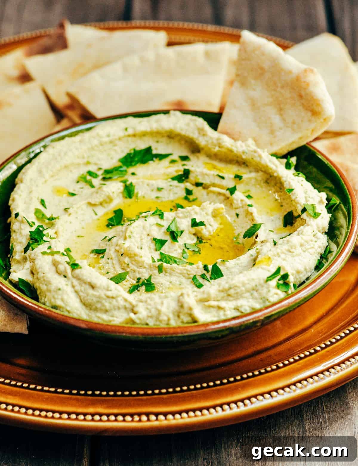 White Bean Hummus served in a green ceramic bowl with pita bread for dipping.