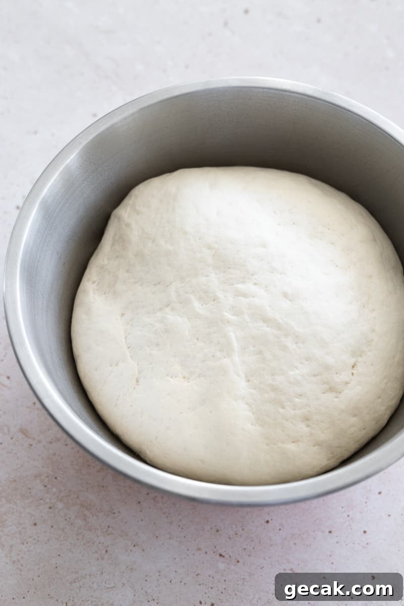 Dough rising in a metal bowl. 
